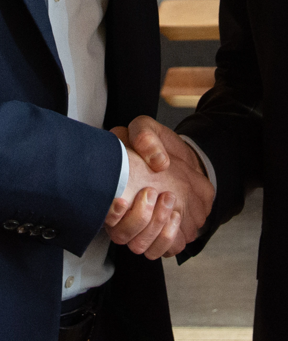 Dos abogados de traje se estrechan la mano
